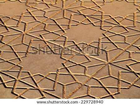 Morocco, Marrakesh, Side-walk with Islamic pattern and symbols lit by the late afternoon sunlight.