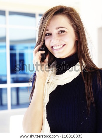 Beautiful business woman talking on cell phone while looking at copyspace