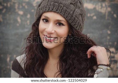 Portrait of a pretty smiling young woman wearing beanie hat