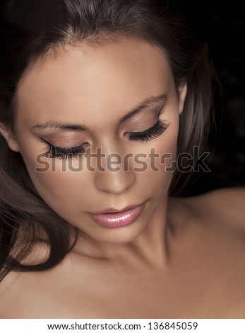 Close up portrait of beautiful young woman\'s face with fake lash extensions