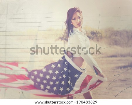 Beautiful young woman holding flag of United States of America in desert background.