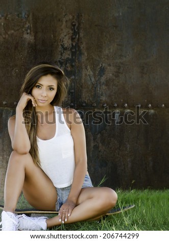 Pretty young woman sitting outside in thoughtful pose with copy space area