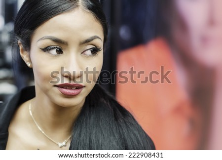 Beautiful young woman turns her head eyes wide open while she shops in mall