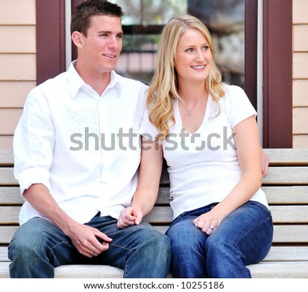 Attractive young snuggle up on a park bench