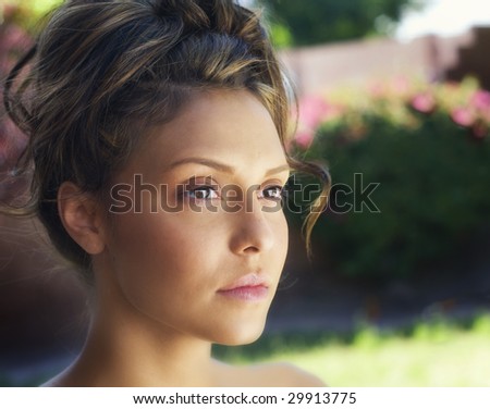 Portrait of a beautiful girl\'s tan face with highlighted hair pulled