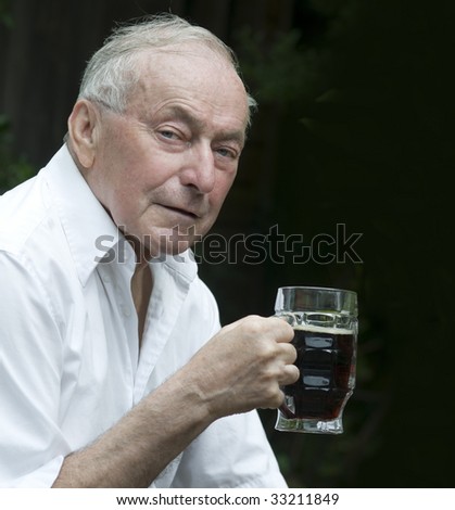 Senior man drinking a beer outside of pub.