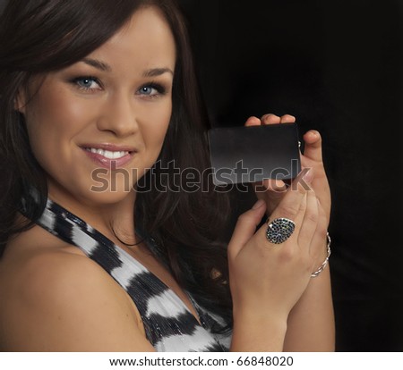 Pretty young woman holding up business card or plastic credit card or vip pass