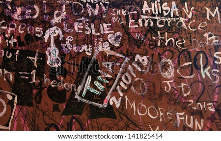 Writing on the Wall - Random words and phrases are scrawled across a wall of an old building.