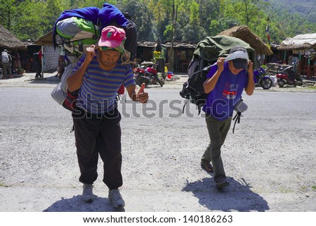 DHAMPUS, NEPAL - MARCH 26 : An unidentified sherpa carrying heavy load on his back in Dhampus , Nepal on March 26,2013 .Sherpas are highly regarded as elite mountaineers and experts in the Himalayas.