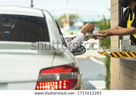 Hand of man from the car is picking a cup of coffee from the salesman by driving through or drive thru. (Social distancing) Foto d'archivio © 