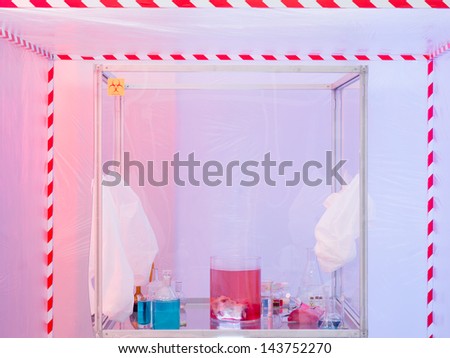 sterile chamber in containment tent with experiment glassware with colored liquid substances and raw meat