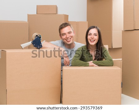happy young couple finishing packing, getting ready to move house