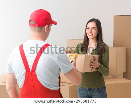 happy young woman receiving a parcel delivered by courier
