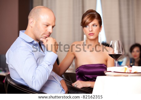 man thinking, sad woman at restaurant table