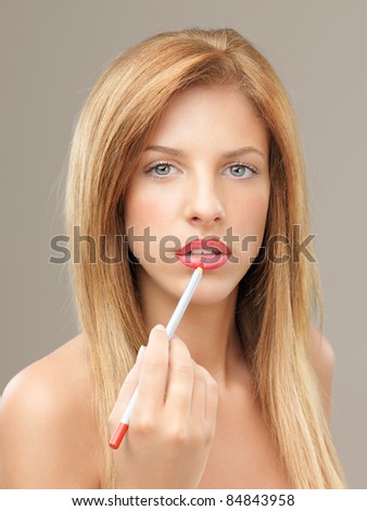 young blonde woman drawing lip contour