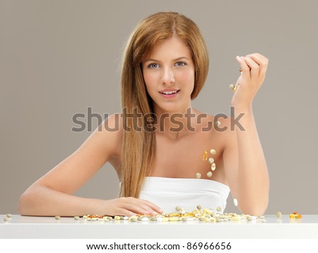 beauty portrait of blonde woman pouring pills from her hand smiling