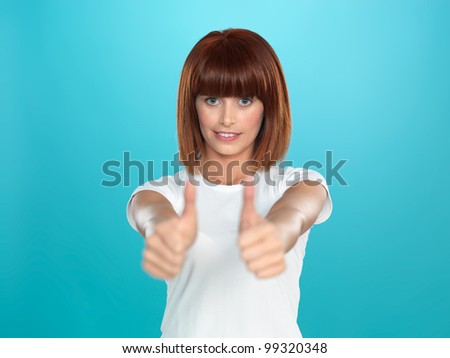 beautiful, young woman smiling and showing an ok sign with her hands, on blue background
