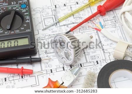 Still Life Of Electrical Components Arranged On Plans. Centered on a light bulb.