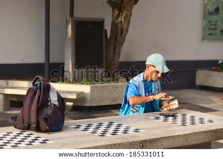 LIMA, PERU - MARCH 5, 2012: Unidentified street money exchanger counting Peruvian soles bills at outdoor table in Miraflores on March 5, 2012 in Lima, Peru. Mobile money exchangers are common in Lima