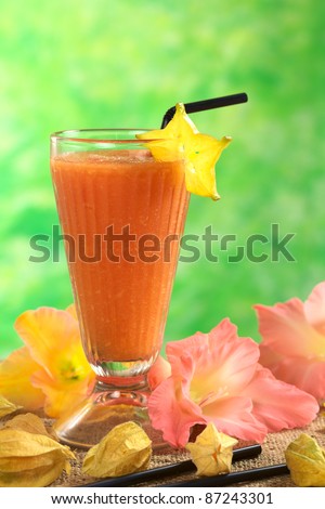 Fresh papaya juice garnished with a carambola slice (Selective Focus, Focus on the carambola and the upper part of the glass)