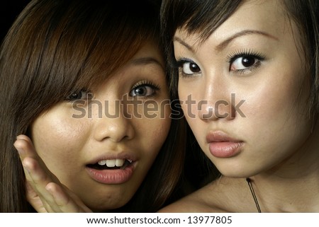 Two surprised asian lady friends
