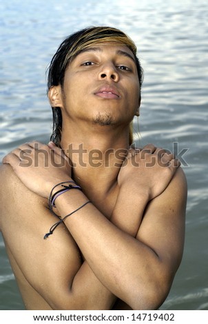Asian man crossed arms pose at seaside
