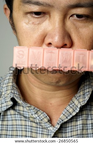 Sad man and pill box on mouth
