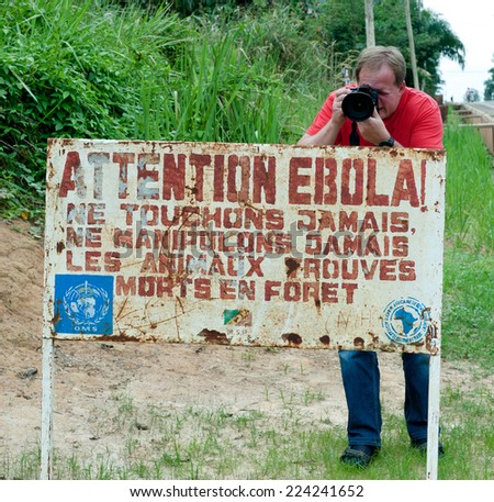 MAKOUA, CONGO, AFRICA - SEPTEMBER 27: Journalist and sign warns visitors that area is a Ebola infected. Signage informing visitors that it is a ebola infected area. September 27, 2013,Congo, Africa.