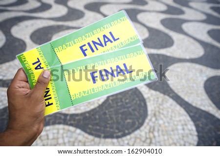 Hand holds pair of tickets to final football soccer World Cup event in Copacabana Rio de Janeiro Brazil