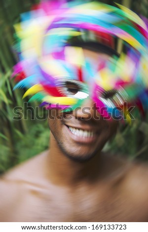 Rio Carnival scene features samba dancing Brazilian man smiling in colorful mask in jungle