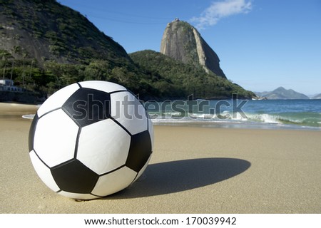 Football soccer ball sits on Red Beach at the foot of Pao de Acucar Sugarloaf Mountain Rio de Janeiro Brazil