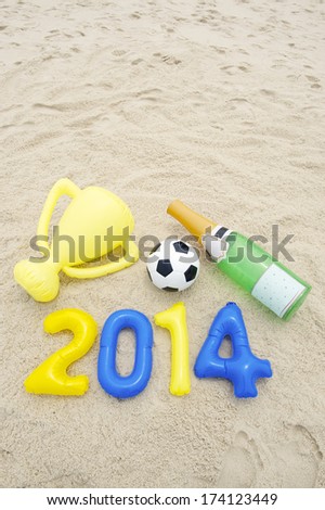 Celebrating 2014 winning with soccer ball football, inflatable trophy, and champagne bottle
