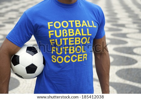 Brazilian soccer player wearing international football shirt holding soccer ball at Copacabana Beach boardwalk Rio de Janeiro