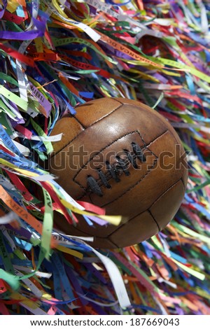 Vintage brown football soccer ball at wall of Brazilian wish ribbons at the Bonfim church in Salvador Bahia Brazil