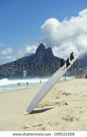Surfboard sticking upside down in the sand on the beach at Ipanema, Rio de Janeiro Brazil