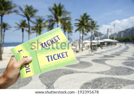 Hands holding pair of tickets to football soccer event in Copacabana Rio de Janeiro Brazil