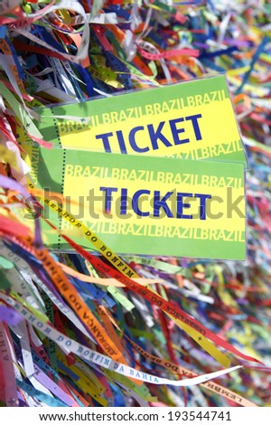 Pair of Brazil tickets in front of background of colorful Brazilian lembranca wish ribbons