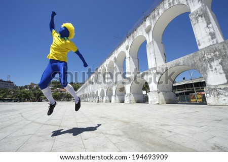 Excited blue Brazilian football player spectator celebrating in team colors at Lapa Arches in Rio de Janeiro