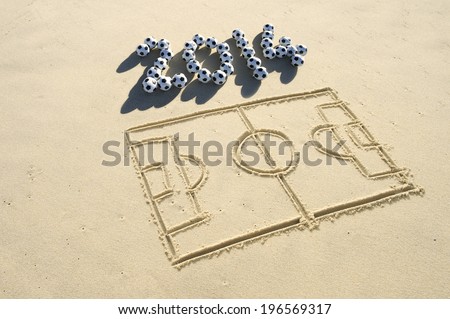 Simple line drawing of football pitch with soccer ball 2014 message in sand on Brazilian beach