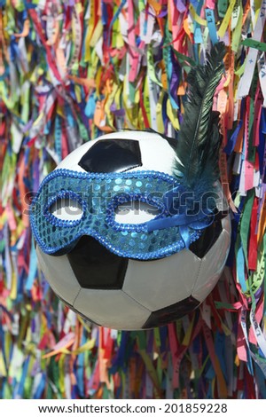 Football wearing blue sequined carnival mask in a background of Brazilian wish ribbons Salvador Bahia Brazil