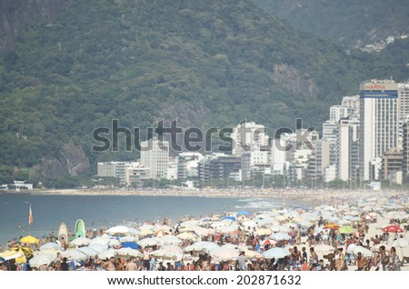 RIO DE JANEIRO, BRAZIL - FEBRUARY 01, 2014: People crowd the beach on a summer morning in Ipanema.
