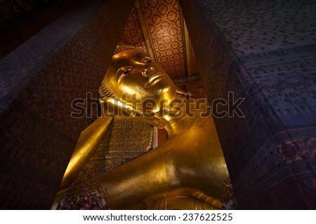 Temple of the Reclining Buddha in Bangkok Thailand close-up of the giant golden statue head and shoulders