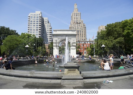 NEW YORK CITY, USA - JUNE 2014: People gather at the fountain in Washington Square Park on a bright summer afternoon.