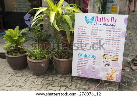 KOH PHI PHI, THAILAND - NOVEMBER 13, 2014: Sign advertising Thai massage services sits in an alley in the tourist center.