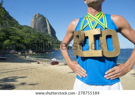 RIO first place athlete wearing gold medals standing outdoors in front of Sugarloaf Mountain Rio de Janeiro Brazil