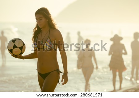 RIO DE JANEIRO, BRAZIL - FEBRUARY 23, 2014: A young Brazilian woman holds a football on Ipanema Beach in a game of keepy uppy beach soccer at Posto 9, a gathering place for the game, called altinho.
