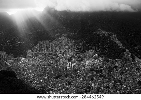 Shafts of sun break through the clouds over the crowded Brazilian Rocinha favela shanty town in Rio de Janeiro Brazil
