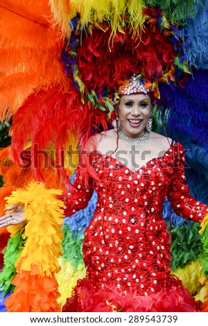 NEW YORK CITY, USA - JUNE 30, 2013: Drag queen celebrates the annual gay pride event in dramatic rainbow dress with matching headdress.