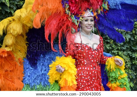 NEW YORK CITY, USA - JUNE 30, 2013: Drag queen celebrates the annual gay pride event in dramatic rainbow dress with matching headdress and boa.
