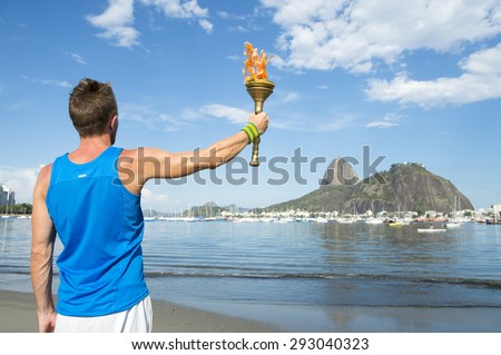 Athlete holding sport torch against Rio de Janeiro Brazil skyline with Sugarloaf Mountain